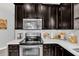 Modern kitchen with dark cabinets, stainless steel appliances and quartz countertop at 2599 Nouveau Way, Kissimmee, FL 34741