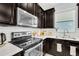 Stylish kitchen with dark cabinetry, stainless steel appliances, and mosaic backsplash at 2599 Nouveau Way, Kissimmee, FL 34741