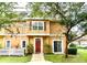 Charming two-story townhome with a red front door, white picket fence, and landscaping at 2601 Gala S Rd # 107, Kissimmee, FL 34746