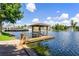 Wooden gazebo and dock on a serene lake with a water fountain at 2601 Gala S Rd # 107, Kissimmee, FL 34746
