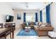 Spacious living room with sectional sofa, blue area rug, and dining table for four at 2601 Gala S Rd # 107, Kissimmee, FL 34746