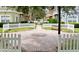 Charming community courtyard with brick pavers, white picket fence, and a shaded seating area at 2601 Gala S Rd # 107, Kissimmee, FL 34746