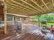 Wooden deck with rocking chairs and backyard access at 4711 County Road 134, Wildwood, FL 34785