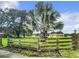 Wooden fence and palm tree in front of home at 4711 County Road 134, Wildwood, FL 34785