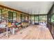Large screened porch with wooden deck and backyard access at 4711 County Road 134, Wildwood, FL 34785