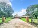 Long driveway leading to a ranch-style home with brick pillars at 4711 County Road 134, Wildwood, FL 34785