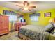 Bedroom with wood furniture, ceiling fan, and large bed at 4711 County Road 134, Wildwood, FL 34785