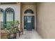 Inviting front entrance with a dark green door and arched window at 16208 Magnolia Hill St, Clermont, FL 34714
