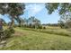 Open grassy backyard with mature trees and distant view at 16208 Magnolia Hill St, Clermont, FL 34714