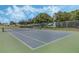 Full-size tennis court with a net and green surface, ideal for sports enthusiasts at 16208 Magnolia Hill St, Clermont, FL 34714