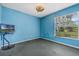 Light blue bedroom with window, TV, and carpet at 16208 Magnolia Hill St, Clermont, FL 34714