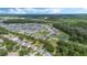 Aerial view of a large community with numerous houses, lush green spaces, and a serene lake at 16208 Magnolia Hill St, Clermont, FL 34714