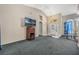 Living room features a large TV, a wooden media cabinet, and carpeted floors at 16208 Magnolia Hill St, Clermont, FL 34714