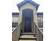 Exterior view of condo building entrance with stairs and brown door at 6312 Raleigh St # 513, Orlando, FL 32835