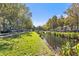 Peaceful canal-side walkway with lush landscaping and parked cars at 720 Celebration Ave # 220, Celebration, FL 34747