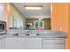 Kitchen with white cabinets, stainless steel appliances, and orange walls at 720 Celebration Ave # 220, Celebration, FL 34747