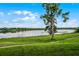 Scenic view of a lake with a tree and grassy shoreline at 1052 Lotus Cove Ct # 743, Altamonte Springs, FL 32714