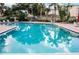 Community pool with palm trees, ample seating, and clear blue water at 1052 Lotus Cove Ct # 743, Altamonte Springs, FL 32714