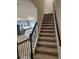 Elegant staircase with black metal railing overlooking kitchen at 14315 Sapelo Beach Dr, Orlando, FL 32827