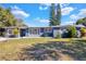 Ranch-style home with gray exterior, red door, and manicured lawn at 701 Sioux Dr, Orlando, FL 32807