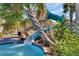 Close-up of a waterslide nestled in tropical foliage at 1638 Moon Valley Dr, Davenport, FL 33896
