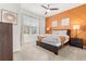 Bright bedroom with orange accent wall, comfortable bed, and ceiling fan at 2163 Copper Bell Pl, Kissimmee, FL 34747