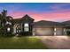 Two-story home with a two-car garage, and landscaped yard at dusk at 7396 Vista Park Blvd, Orlando, FL 32829