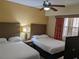 Two twin beds, nightstands, and a TV in a well-lit bedroom at 12527 Floridays Resort Dr # 510E, Orlando, FL 32821