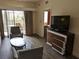 Living room with sofa, chairs, and a large TV, offering access to balcony at 12527 Floridays Resort Dr # 510E, Orlando, FL 32821