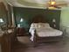 Main bedroom with large bed, dark wood furniture and green walls at 3635 Daydream Pl, Saint Cloud, FL 34772