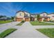 Tan two-story townhome with a double garage at 1714 Wynford Cir, Tavares, FL 32778