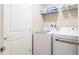 Bright laundry room with washer, dryer, and shelving at 7944 Formosa Valley Pl, Kissimmee, FL 34747