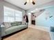 Bright living room with teal walls, comfy sofas, and a ceiling fan at 1526 White Hawk Way, Groveland, FL 34736