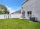 Backyard with grassy area, privacy fence, and AC unit at 1526 White Hawk Way, Groveland, FL 34736