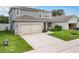 Two-story house with gray siding, solar panels, and a two-car garage at 1526 White Hawk Way, Groveland, FL 34736