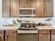 Stainless steel range and microwave in a modern kitchen at 1526 White Hawk Way, Groveland, FL 34736