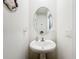 Small bathroom with pedestal sink and oval mirror at 1526 White Hawk Way, Groveland, FL 34736