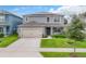 Two-story house with gray siding, solar panels, and a two-car garage at 1526 White Hawk Way, Groveland, FL 34736