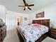Main bedroom with large bed, dresser, ceiling fan and en-suite bathroom at 1526 White Hawk Way, Groveland, FL 34736