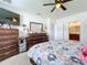 Main bedroom with dresser, large bed, ceiling fan and en-suite bathroom at 1526 White Hawk Way, Groveland, FL 34736