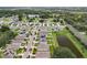 Aerial view of a residential neighborhood with houses and a pond at 1526 White Hawk Way, Groveland, FL 34736