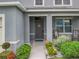 Front entry with gray door and landscaping at 1526 White Hawk Way, Groveland, FL 34736