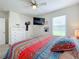 Bright bedroom with a large bed, dresser, and TV at 1526 White Hawk Way, Groveland, FL 34736