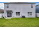 Two-story house back with solar panels, sliding glass doors, and a grassy backyard at 1526 White Hawk Way, Groveland, FL 34736