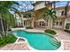 Freeform swimming pool and spa with a screened enclosure at 9164 Point Cypress Dr, Orlando, FL 32836