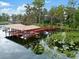 Covered boat dock with multiple boat slips on a calm lake at 9164 Point Cypress Dr, Orlando, FL 32836