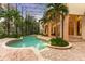 Relaxing pool area with brick patio, lush landscaping, and screened enclosure at 9164 Point Cypress Dr, Orlando, FL 32836