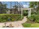 Brick pathway winds through a well-manicured garden with lush greenery at 9164 Point Cypress Dr, Orlando, FL 32836