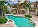 Freeform pool with spa and screened patio area at 9164 Point Cypress Dr, Orlando, FL 32836