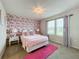 Bright bedroom featuring a floral accent wall and pink rug at 3397 Lilac Way, Davenport, FL 33897